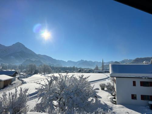 a view of a snow covered field with a building at Haus Anna in Fischen