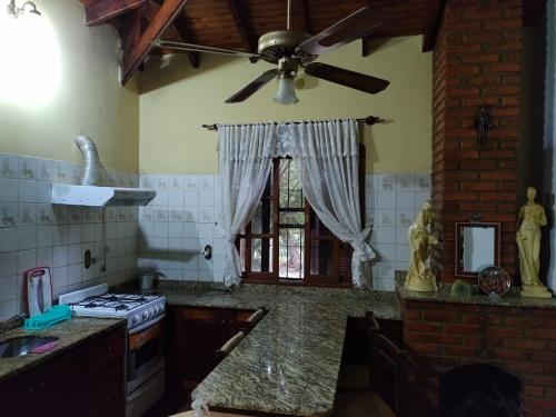 a kitchen with a ceiling fan and a stove at Quinta La calmita Iguazú in Puerto Iguazú