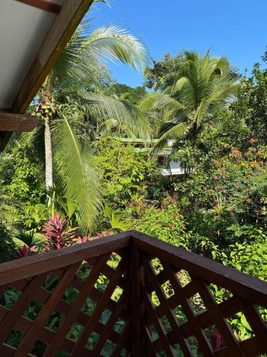 a view of a garden from a wooden balcony at Passion Fruit Lodge in Cahuita