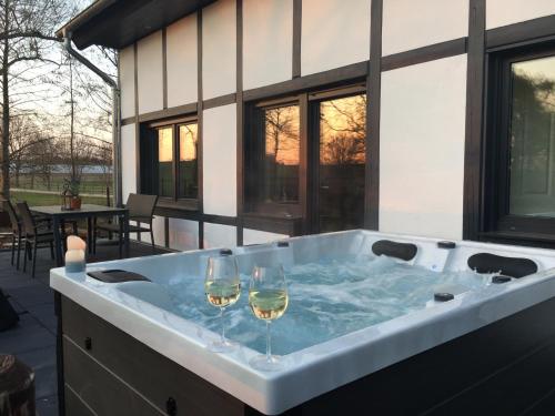 a hot tub with two glasses of wine at Landhaus Bachglück in Zülpich
