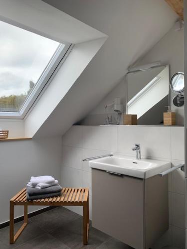 ein weißes Badezimmer mit einem Waschbecken und einem Spiegel in der Unterkunft Landhaus Bachglück in Zülpich