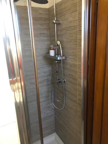 La salle de bains est pourvue d'une douche avec un tuyau. dans l'établissement Moon River Guest House, à Pescara