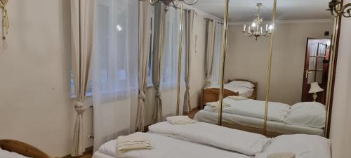 um quarto com quatro camas e um espelho em Apartament Łomnicki em Karpacz