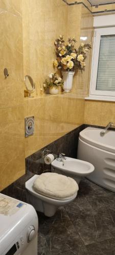 uma casa de banho com WC, bidé e flores em Apartament Łomnicki em Karpacz