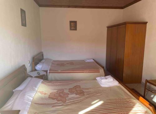 a small bedroom with two beds and a cabinet at ΑΓΝΑΝΤΕΜΑ in Elati Trikalon