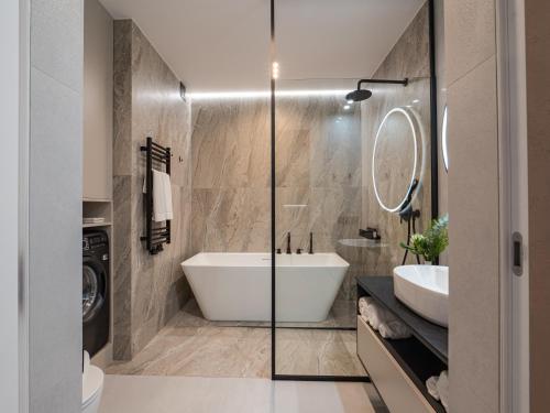 een badkamer met een bad en een wastafel bij Loft House Apartments in Wrocław