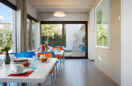 ein Esszimmer mit Tischen und Stühlen und einem großen Fenster in der Unterkunft Hotel Villa Sveva in Cagliari