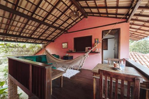 a room with a hammock and a house at Pousada Caraiva Guest House in Caraíva