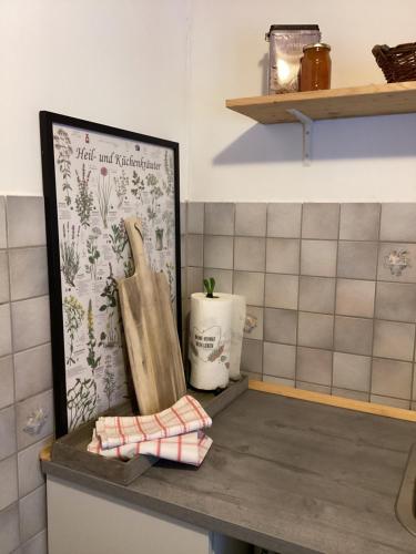 a kitchen counter with a cutting board and a picture at Apartement für Naturliebhaber in Fischbachau