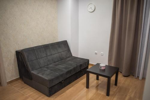 a black leather couch in a living room with a table at La Mirage in Šabac