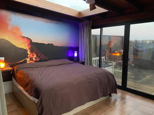 a bedroom with a fire mural on the wall at Exclusive Stars view Experience in La Oliva