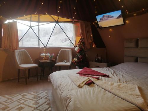a bedroom with a bed and a christmas tree and a window at Bubble castle house in Kerak