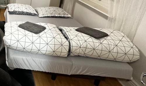 two beds with pillows on them in a room at independent apartment near citycenter/lake in Borås