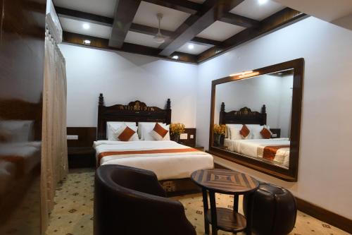 Pokój hotelowy z 2 łóżkami i lustrem w obiekcie Hotel Lok Sagar Mysore w mieście Mysuru