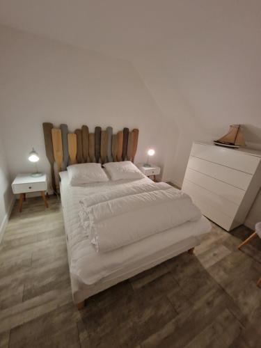 a bedroom with a large bed and a white dresser at Maison en pierre accès 5 mn à pied plage in Arzon