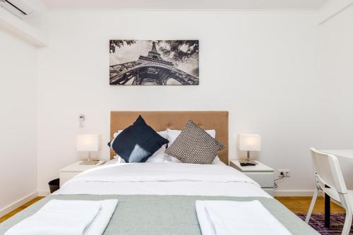 um quarto com uma cama e uma fotografia da Torre Eiffel em Mia Guest House em Setúbal