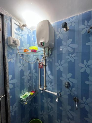 a blue tiled bathroom with a shower in it at Patil Homestay in Alibag