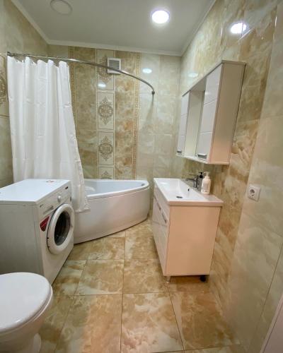 a bathroom with a tub and a toilet and a sink at APARTAMENT в мкр Батыс-2 в комфортном ЖК Нектар in Aktobe