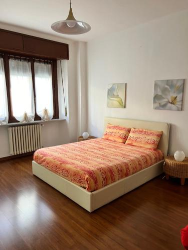 una camera da letto con un letto con lenzuola arancioni e due cuscini di Al Teatro Romano - CIR 0343 ad Aosta