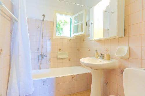 y baño con lavabo, bañera y ducha. en Evanna House in Saint Stephanos, en Ágios Stéfanos