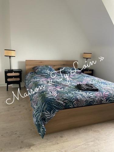 une chambre avec un lit avec une couette dessus dans l'établissement Villa Ty Loin vue mer 8 personnes, à Logonna-Daoulas