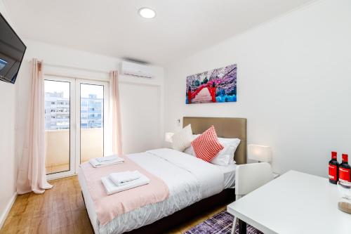 a bedroom with two beds and a window at Mia Guest House in Setúbal