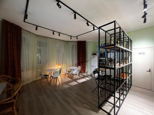 een woonkamer met een tafel en stoelen en een plank bij Friends Hostel in Astana