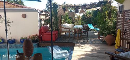 un patio avec une table et des chaises à côté d'une piscine dans l'établissement En Alsace, Le 49, à Mittelbergheim