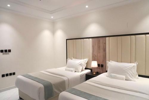 two beds in a hotel room with white walls at لـحظــات حــراء in Jeddah