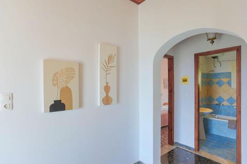 pasillo con 2 cuadros en la pared y baño en Irena Saint Stephanos, en Ágios Stéfanos