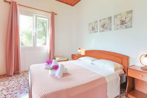 un dormitorio con una cama con dos animales de peluche en Irena Saint Stephanos, en Ágios Stéfanos