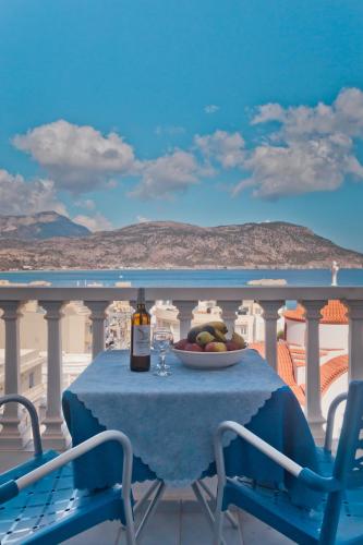 a table with a plate of fruit and a bottle of wine at Regina Studios & Hotel in Karpathos Town