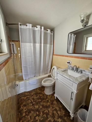 a bathroom with a toilet and a sink and a shower at Royal Inn Motel in Perry