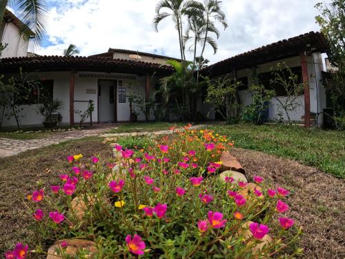 un giardino di fronte a una casa con fiori rosa di Condomínio Terra Pura a Ilhéus