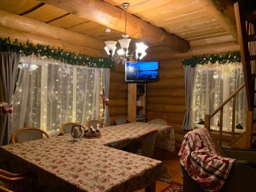 a dining room with a table and a tv at Kundziņi in Bīriņi