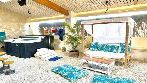 een kamer met een veranda met een bed en een bank bij La Grange - Gîte de Prestige La Rochelle in Saint-Médard-dʼAunis