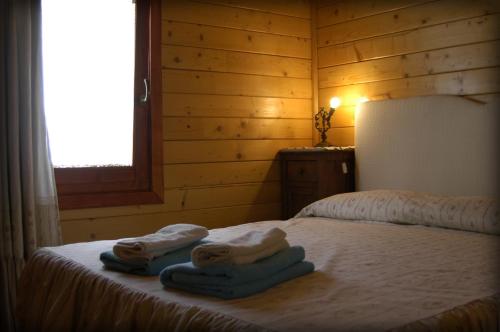 a bedroom with towels on a bed with a window at Bosco D'Olmi Country House in SantʼAndrea del Garigliano