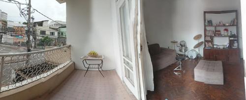 Cette chambre dispose d'un balcon avec une table et une fenêtre. dans l'établissement Quarto Luxury, à Vitória