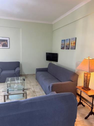 a living room with two blue couches and a table at Ambracian Gulf Comfort House in Menídion