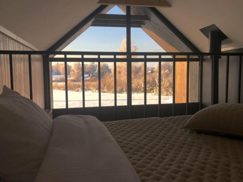 a bedroom with a bed and a large window at WakeMālpils brīvdienu mājas in Mālpils