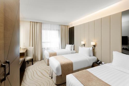 una camera d'albergo con 2 letti e una scrivania di فندق جايدن-Jayden Hotel a Medina