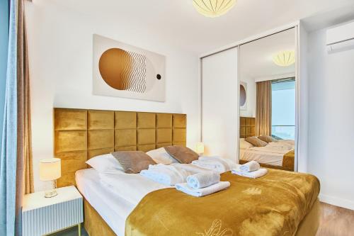 1 dormitorio con 2 camas y un espejo grande en Wave Panorama Apartment - Sea View&SPA en Międzyzdroje
