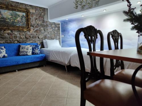 a bedroom with a bed and a blue couch at Naupactus unique harbor apartment in a stone house! in Nafpaktos