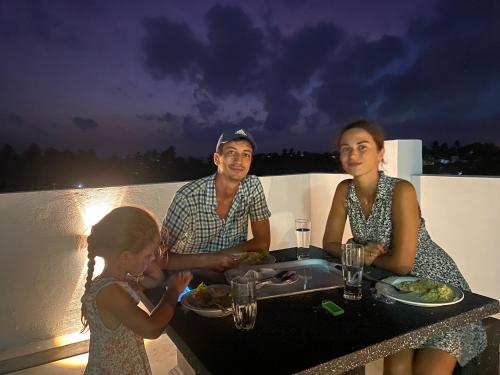 a man and a woman sitting at a table with a girl at Apartment near Colombo Airport in Katunayake