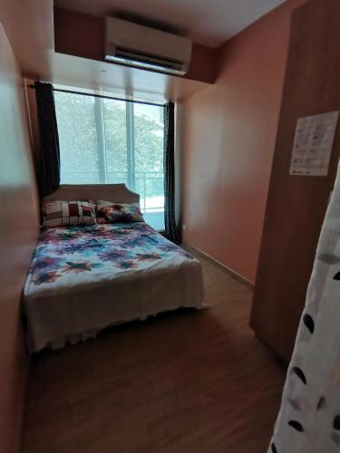 sypialnia z łóżkiem i dużym oknem w obiekcie Azure Urban Resort Residences w mieście Manila