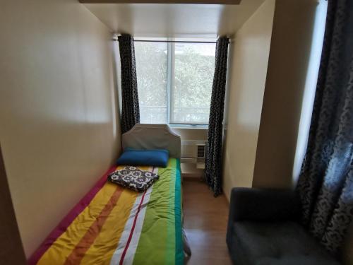 mały pokój z łóżkiem i oknem w obiekcie Azure Urban Resort Residences w mieście Manila