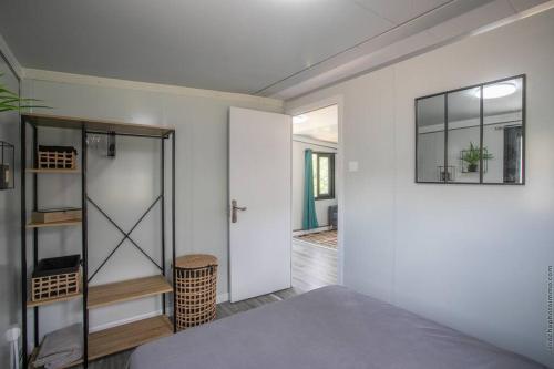 Schlafzimmer mit einem Bett, einem Spiegel und einer Tür in der Unterkunft Éco-Chic Bungalow by Bungazur in Saint-Joseph