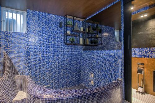 eine blau geflieste Dusche mit einer Bank im Bad in der Unterkunft Heart of Reykjavik-Luxury Apartments in Reykjavík