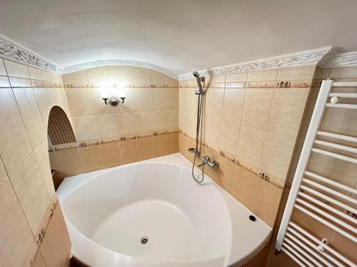 a large white tub in a bathroom with tiles at APARTMENTS on SHOLOM ALEICHEM та ще варіант поруч in Lviv