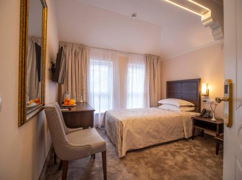 a bedroom with a bed and a chair and a window at The Moon Boutique Hotel in Sofia